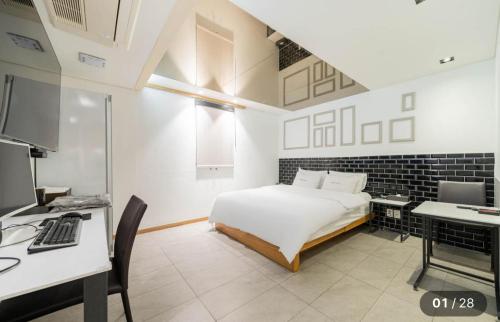 a bedroom with a bed and a desk with a computer at Hotel Cherry in Seoul