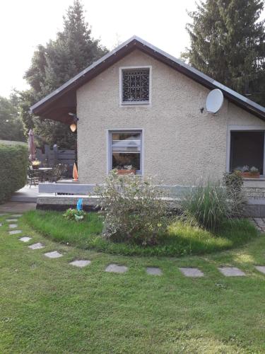 a house with a window and a yard with grass at Bungalow am Silbersee in Kittlitz