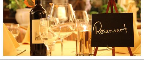 Hotel "Die Kupferpfanne" في دوناوستاف: مجموعة من كؤوس النبيذ على طاولة مع زجاجة من النبيذ
