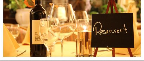 a group of wine glasses on a table with a bottle of wine at Hotel "Die Kupferpfanne" in Donaustauf