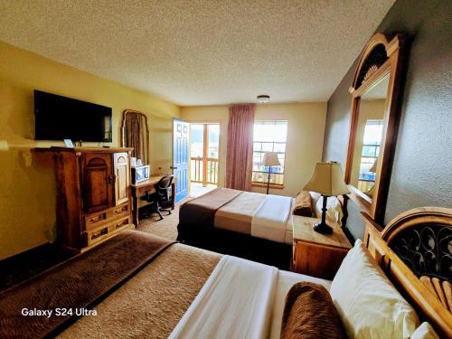 a hotel room with two beds and a television at Enchanted Escape Lodge in Eagle Nest