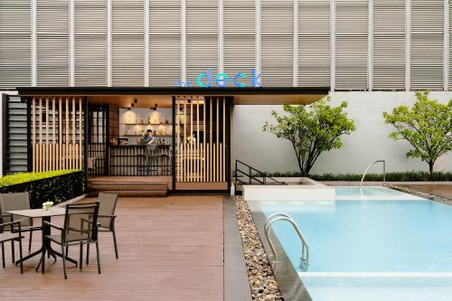 a restaurant with a table and a swimming pool at Avani Sukhumvit Bangkok Hotel in Bangkok