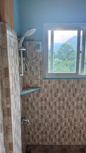a bathroom with a shower with a window at Cliffhouse Kalinga in Tinglayan