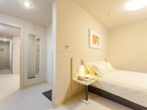 a bedroom with a bed and a table with a mirror at Jinjiang Inn Anyang Railway Station in Anyang