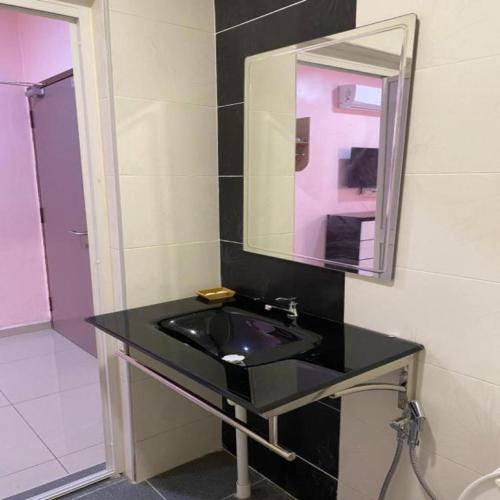 a bathroom with a black sink and a mirror at HOTEL SAKIRAH in Kampong Bemban