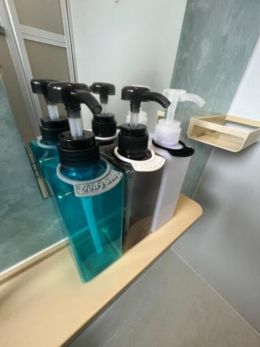 een plank met drie flessen tandenborstels bij 伊勢ヒルトップ アパートメント in Ise