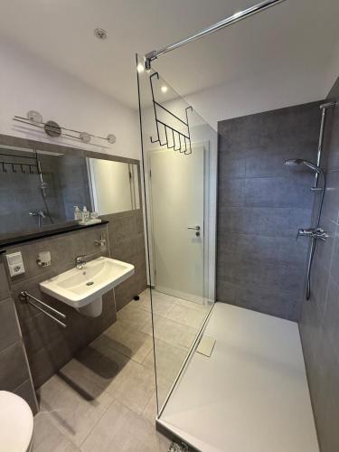 un bagno con doccia in vetro e lavandino di Fe-Wo B6 1 a Kenn