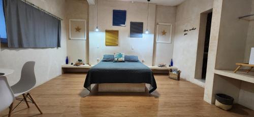 a bedroom with a bed with a blue blanket on it at Suite Stella Maris en el Centro Histórico Carmen in Ciudad del Carmen