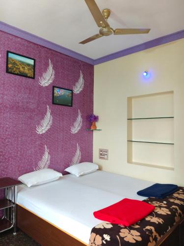 a bedroom with a bed with a red blanket on it at Vinayaka Homestay Hampi in Hampi