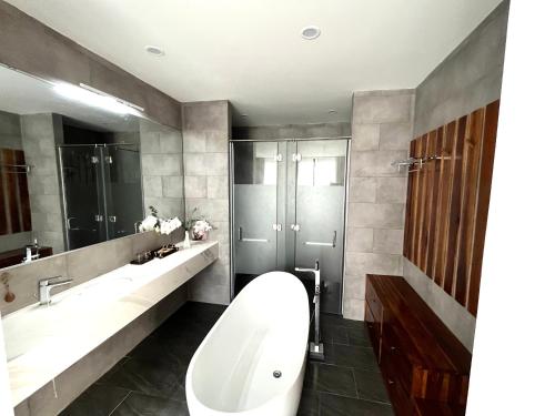 a bathroom with a large white tub and a sink at Biệt thự nghỉ dưỡng Saint Simeon Long Hải in Ấp Phước Tĩnh