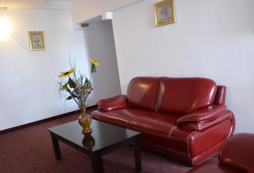 a red leather chair sitting in a room with a table at Hotel Europolis in Tulcea