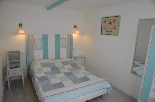 a bedroom with a checkered bed and a tv at Maisonnette Gatseau in Saint-Trojan-les-Bains