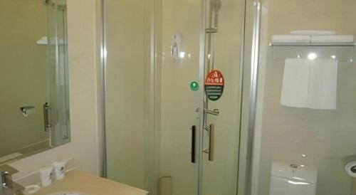 a bathroom with a shower with a glass door at GreenTree Inn Yixing Zhangzhu Express Hotel in Xinchating