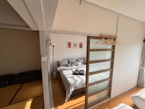 een kamer met een bed in een kamer met een glazen deur bij 伊勢ヒルトップ アパートメント in Ise