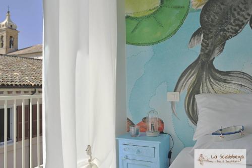 a room with a bed and a wall with a mural at La Sciabbega B&b in Porto Recanati