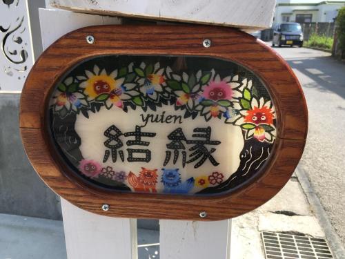 a sign on a parking meter with flowers on it at Shimanchu Guest House Yuien in Nanjo