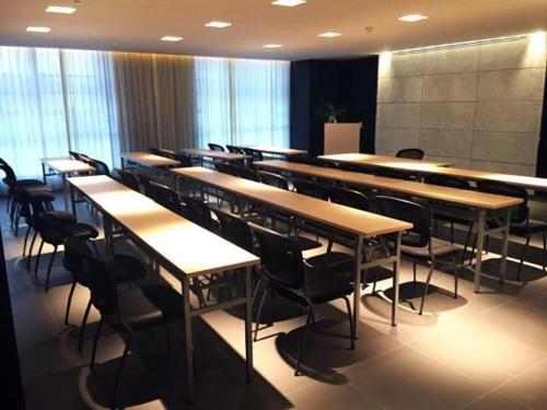 a room with rows of tables and chairs with windows at Jinjiang Inn Select Jiaxing Wanda Plaza in Jiaxing