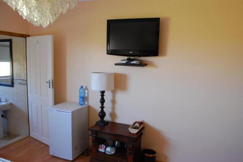 a room with a flat screen tv on the wall at Royal Thokazi Lodge in Nongoma