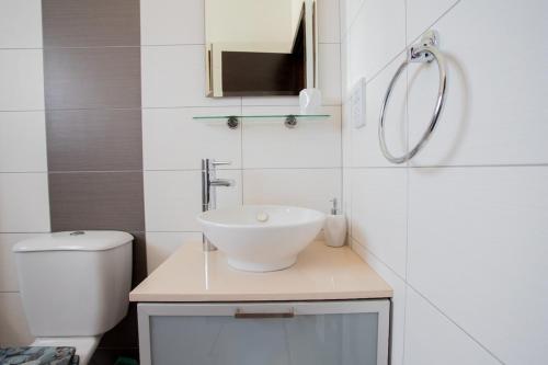 a white bathroom with a sink and a toilet at Tranquil hideaway with breathtaking sea views in Kissonerga