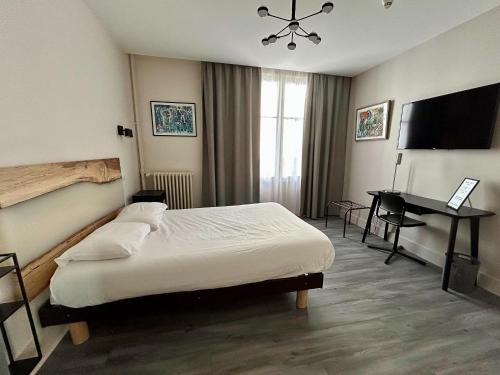 a bedroom with a bed and a desk and a television at Trianon in Vichy