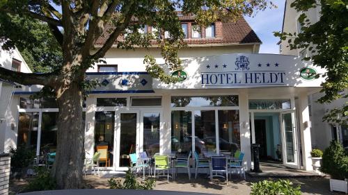 un hotel helvética con sillas fuera de él en Hotel Heldt en Bremen