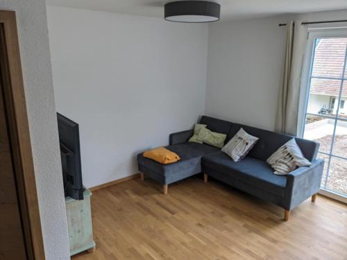 a living room with a blue couch and a tv at Fewo Schwarzwälder Blattert in Lembach