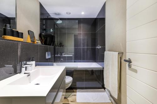 a bathroom with a sink and a toilet and a tub at Danbury on Loop - Designer Apartment in Cape Town in Cape Town