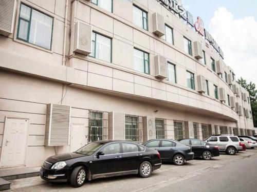 a row of cars parked in front of a building at Jinjiang Inn Wuxi Central Station in Wuxi