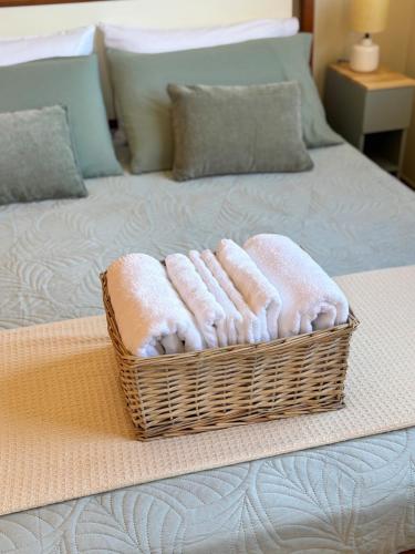 a basket of towels sitting on top of a bed at La Casetta in Cagliari