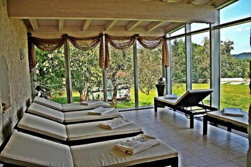 a room with four beds and a large window at Hotel Hirschenstein in Achslach