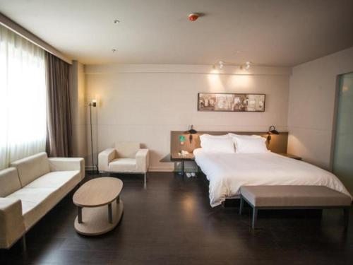 1 dormitorio con 1 cama blanca grande y 1 sofá en Jinjiang Inn Select Fuding Railway Station en Fuding