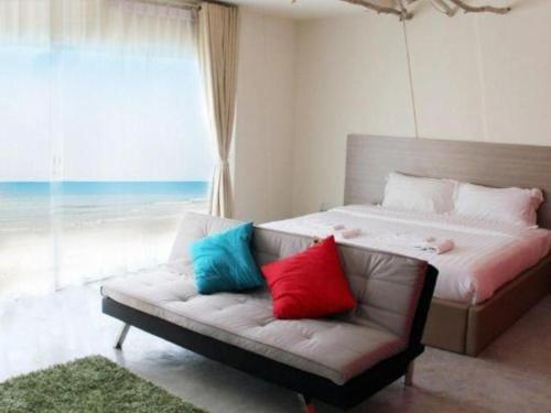 a bedroom with a couch with colorful pillows on it at Red Z The Ocean in Ban Tanot Noi