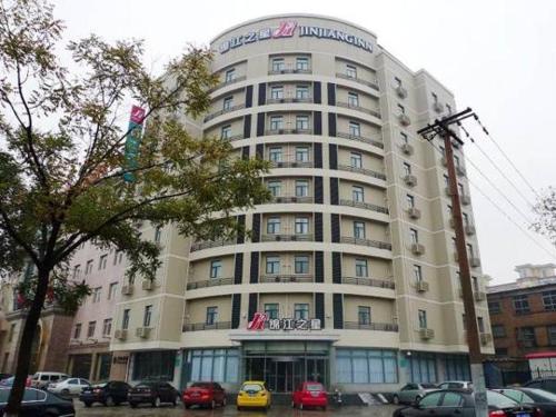 a large building with cars parked in front of it at Jinjiang Inn Baoding Military School Square in Baoding