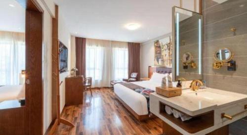 a bedroom with a bed and a bathroom with a sink at James Joyce Coffetel·Bao Ji Gao Tie Nan Zhan in Baoji