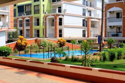 an apartment complex with a swimming pool in front of a building at 1bhk Premium BS1 - Candolim Calangute Area in Candolim