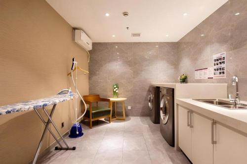 a laundry room with a sink and a washing machine at Yitel Collection Shenyang Imperial Palace Zhongjie Metro Station in Shenyang
