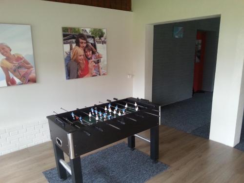 a black game table in a room with pictures on the wall at Ośrodek Wczasowy Łowiczanka in Wisełka