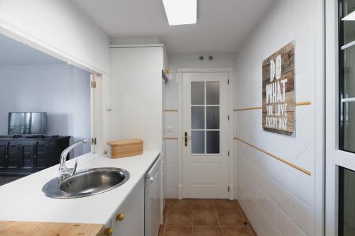 a bathroom with a sink and a door at Vista Marina de Isla Canela in Isla del Moral