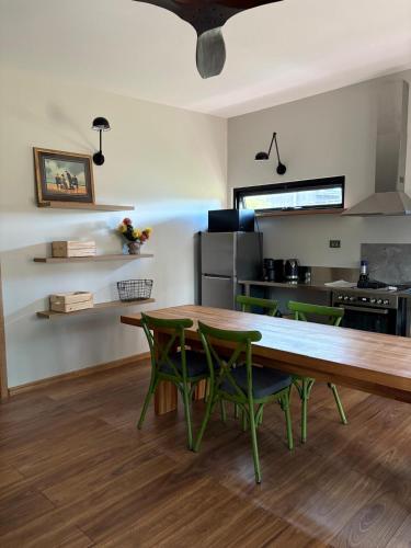 a dining room with a wooden table and green chairs at Barn Hives Yallingup in Yallingup