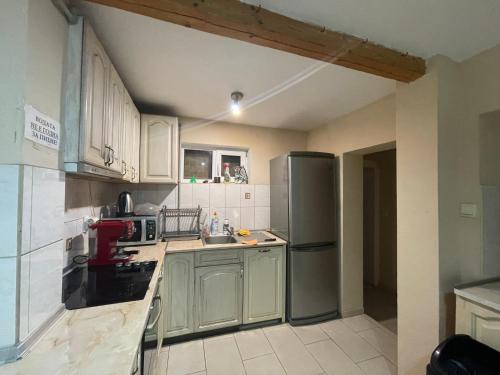 a kitchen with white cabinets and a stainless steel refrigerator at Guest House Robin Hud in Cherni Osŭm