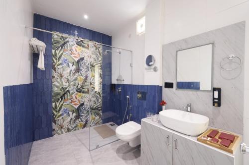 a bathroom with a sink and a toilet and a shower at WelcomHeritage Arka Resort & Spa, Rishikesh in Bijni