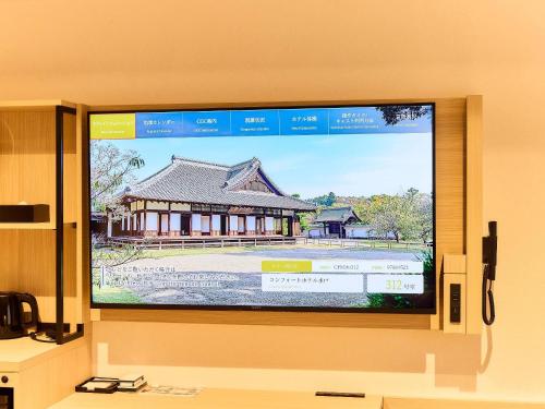 a large flat screen tv on a wall at Comfort Hotel Mito in Mito