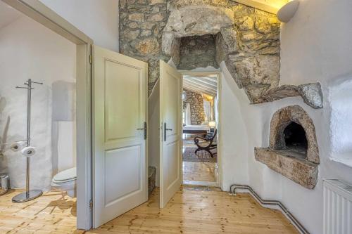 a hallway with a bathroom with a stone fireplace at Beautiful stone holiday house MENTA I in Bajčići