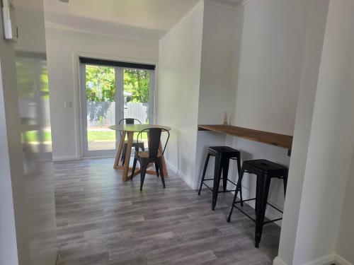 a dining room with a table and stools at Modern, House in central Palmerston North in Palmerston North