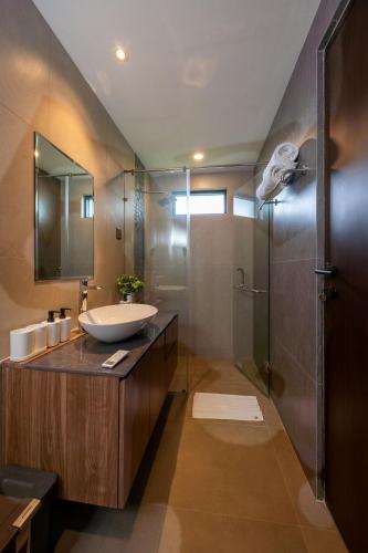 a bathroom with a sink and a shower at Kana Suites Nusa Dua By Fays Hospitality in Nusa Dua