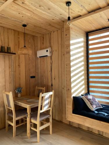 a wooden room with a table and chairs and a window at Будиночок між річками Гирло in Iltsi
