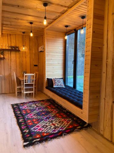 a bench in a room with a rug and a window at Будиночок між річками Гирло in Iltsi