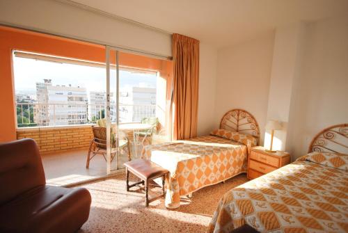 a hotel room with two beds and a large window at Apartamentos Concorde in Alicante