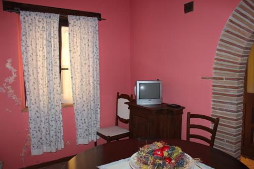a dining room with a table and a tv in a room at Società Agricola F.lli Angelucci in Cannara