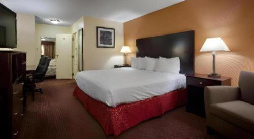 a hotel room with a large bed and a television at Days Inn by Wyndham St. Charles IL in Saint Charles